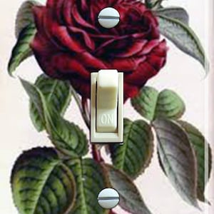Pode incluir: Uma placa de interruptor de luz com uma ilustração vintage de uma rosa vermelha com folhas verdes. A placa do interruptor tem um interruptor de alavanca branco com a palavra "ON" impressa nele.