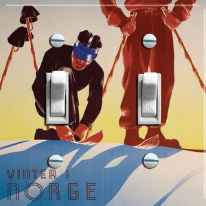 May include: A vintage-style light switch plate featuring a colourful illustration of two skiers in a snowy landscape. The text "VINTER I NORGE" is printed at the bottom of the plate.