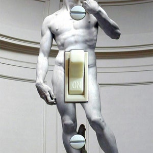 May include: A white statue of a nude man with a light switch on his lower body. The switch is labeled "ON".