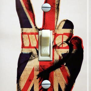 May include: A light switch cover with a vintage peace sign design featuring the Union Jack flag. The switch is white and says "ON".