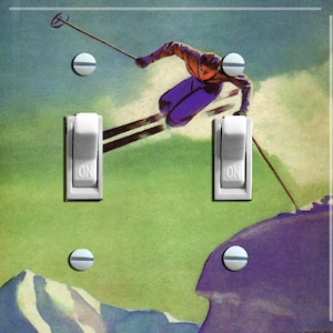May include: A vintage-style light switch plate featuring a skier in mid-air, soaring over a snowy mountain landscape. The skier is wearing a purple and red outfit and is holding ski poles. The background is a vibrant green and blue.