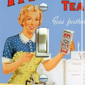 May include: Vintage-style light switch with a retro illustration of a woman holding a box of Ty.Phoo Tea. The image features a tea set on a tray, with the text "Ty.Phoo Tea Goes further" in red and white.