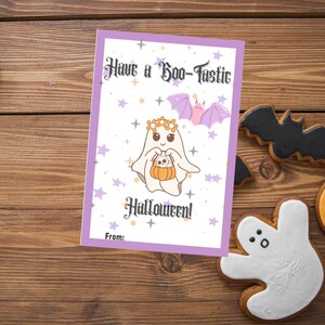 May include: A Halloween greeting card with a purple border and the text "Have a Boo-tastic Halloween!". The card features a cartoon ghost holding a pumpkin, with stars and bats. Halloween-themed cookies surround the card.