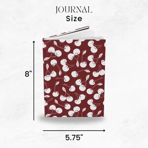 May include: A journal with a cherry pattern on a burgundy background. The journal is 8 inches tall and 5.75 inches wide. The text "JOURNAL Size" is at the top.