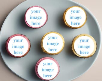 May include: Six cupcakes on a light blue plate. The cupcakes have white frosting with the text "your image here" and are decorated with pink and gold frosting. The plate is round.