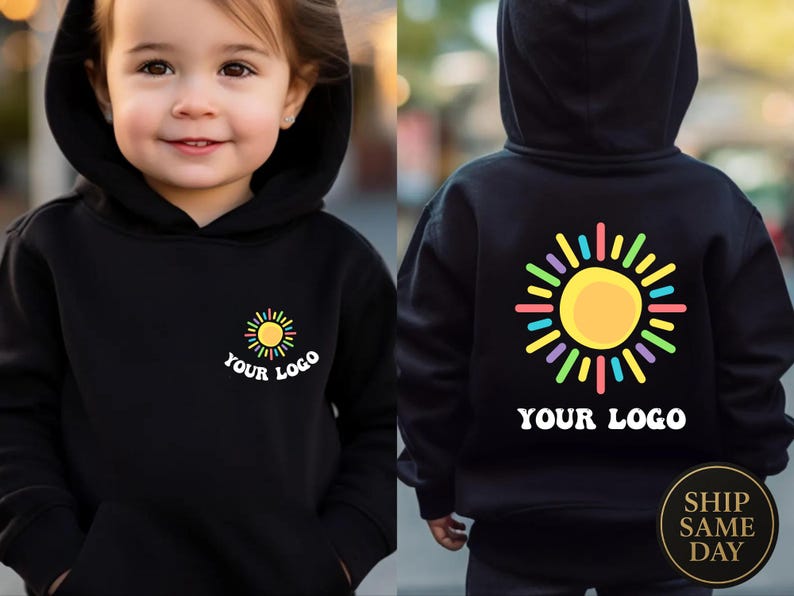 May include: Black hooded sweatshirt with a colorful sun graphic on the front and back. The front of the sweatshirt has the text "YOUR LOGO" below the sun graphic. The back of the sweatshirt also has the sun graphic and the text "YOUR LOGO".