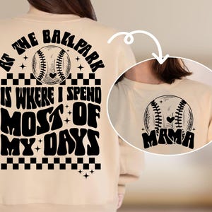 May include: Tan sweatshirt with black text that reads "At the ballpark is where I spend most of my days" with a baseball graphic. The back of the sweatshirt has a baseball graphic with the word "Mama" underneath.