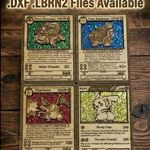 May include: Four wooden laser-cut Pokemon trading cards. Each card features a different Pokemon character with glitter accents. The cards include text such as "Thicc Venusaur," "Thicc Blastoise," "Charizard," and "Thicc Pikachu."
