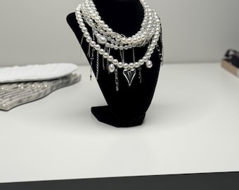 Collar llamativo de perlas con colgantes de corazón y cruz.