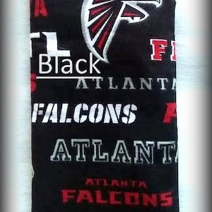 May include: Black and red fabric with the Atlanta Falcons logo and the words "Atlanta Falcons" repeated. The fabric is a soft, plush material.