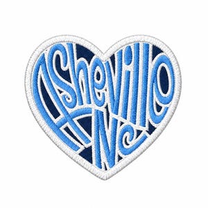 May include: A heart-shaped embroidered patch with a dark navy blue background and a white border. The text Asheville NC is stitched in a bright light blue cursive font that fills the heart shape, creating a bold and clear graphic design.