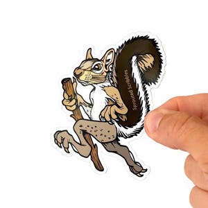 May include: A die-cut vinyl sticker featuring a cartoon squirrel with a large, dark brown bushy tail, standing on its hind legs while holding a wooden walking stick. The squirrel has light brown fur, a white chest, and the text Sprouted Scribbles.