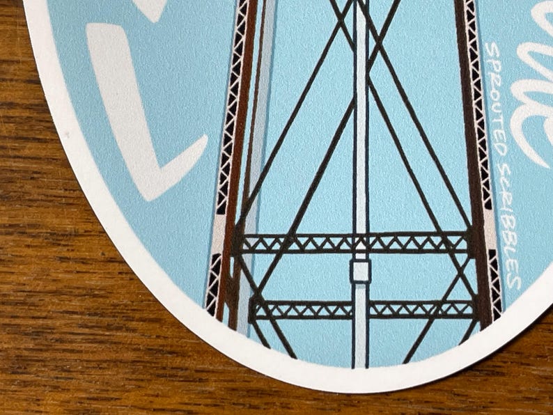 May include: A blue and white sticker with a black and brown illustration of a water tower. The sticker has the text "SPROUTED SCRIBBLES" on the right side.