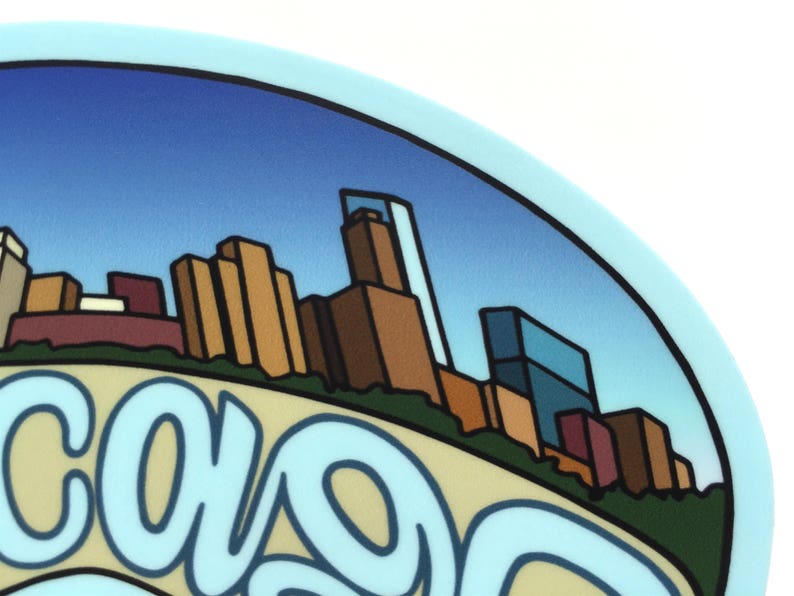 Op de afbeelding: Een blauwe en witte sticker met een gestileerde afbeelding van een skyline en het woord "Chicago" in een blauw, cursief schrift.