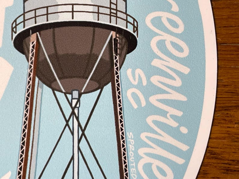 May include: A blue and white sticker featuring a water tower and the text "Greenville, SC" in white cursive writing.