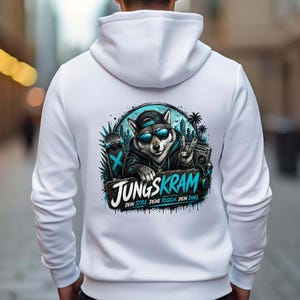 Peut inclure: Un sweat à capuche blanc avec un motif de loup portant des lunettes de soleil et une casquette, avec le texte "JUNGSKRAM". Le design comprend un skateboard, des palmiers et un boombox, en bleu et noir.
