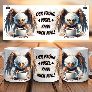May include: White ceramic coffee mugs with an eagle design holding a coffee cup, and the text "DER FRÜHE VOGEL KANN MICH MAL!". The mugs are displayed on a wooden surface.