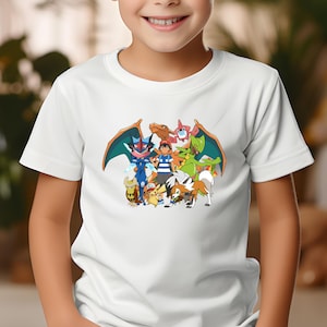 Op de afbeelding: Wit T-shirt met een kleurrijke afbeelding van stripfiguren. Het ontwerp toont een centrale figuur omringd door andere figuren in heldere kleuren. Het shirt is gemaakt van een zacht materiaal en is geschikt voor dagelijks gebruik.