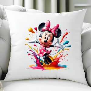 May include: White square cushion featuring a colourful illustration of Minnie Mouse. Minnie is wearing a pink polka dot dress and bow, surrounded by vibrant paint splashes in yellow, blue, pink, and orange.