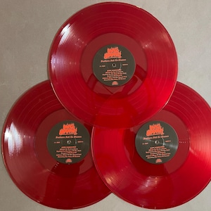May include: Three red vinyl records with the band name "Grave Desecrator" and the album title "Futures Built to Flame" printed on the labels.