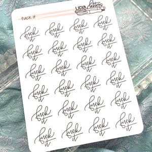 May include: A white sticker sheet featuring twenty individual black ink stickers with the phrase 'fuck it' written in a cursive script. The top of the sheet includes the text 'fuck it' and the brand name 'LICIA letters' with a pen illustration.