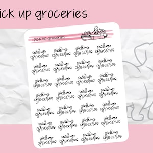May include: White sticker sheet with the text "pick up groceries" in a handwritten font. The sheet has multiple repetitions of the phrase. The background is light pink and white.