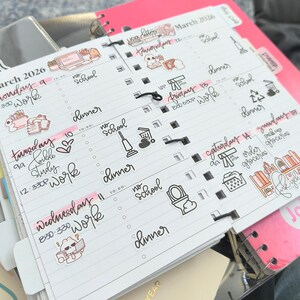 Pode incluir: Uma agenda de espiral branca aberta em mar&ccedil;o de 2026, com hor&aacute;rios di&aacute;rios escritos &agrave; m&atilde;o, listas de tarefas e v&aacute;rios adesivos decorativos. As p&aacute;ginas incluem texto em tinta preta, destaques em rosa e pequenas ilustra&ccedil;&otilde;es de itens dom&eacute;sticos.