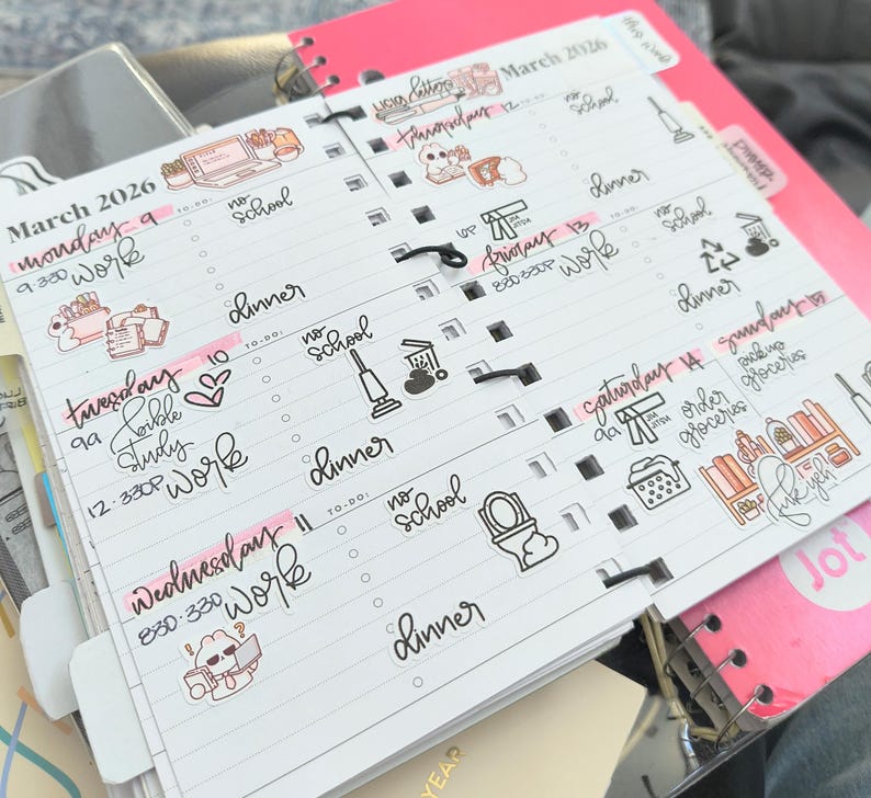 Pode incluir: Uma agenda de espiral branca aberta em mar&ccedil;o de 2026, com hor&aacute;rios di&aacute;rios escritos &agrave; m&atilde;o, listas de tarefas e v&aacute;rios adesivos decorativos. As p&aacute;ginas incluem texto em tinta preta, destaques em rosa e pequenas ilustra&ccedil;&otilde;es de itens dom&eacute;sticos.
