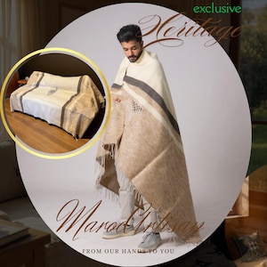 May include: A beige and cream-coloured woven blanket with a striped design and fringe. The blanket is draped over a person and also shown on a sofa. The image includes the text "exclusive Heritage" and "Marod Artisan".