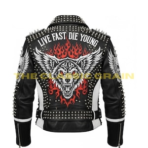 Puede incluir: Chaqueta de cuero negra con detalles blancos, tachuelas plateadas y un diseño de lobo. La chaqueta tiene el texto "LIVE FAST DIE YOUNG" en la espalda y púas plateadas en los hombros.