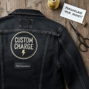 Puede incluir: Chaqueta vaquera negra con un parche circular que dice "CUSTOM CHARGE" con un rayo. Un pequeño parche rectangular debajo dice "YourCustomStitch". Una nota dice "¡PERSONALIZA TU CHAQUETA!"