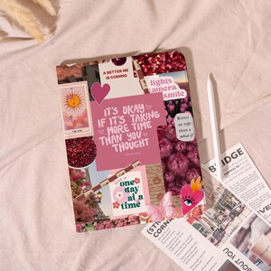 May include: A collage of pink and red images with text, including a tarot card, flowers, and inspirational quotes. A white stylus and a newspaper clipping are also visible.