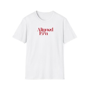 Könnte beinhalten: Weißes T-Shirt mit dem roten Text "Aligned Era" auf der Brust. Das Shirt hat kurze Ärmel und einen Rundhalsausschnitt. Der Text ist in einer stilisierten Schriftart gehalten.
