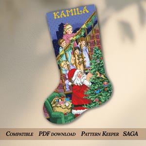 Può includere: Una calza di Natale con un disegno a punto croce raffigurante Babbo Natale che decora un albero di Natale. I bambini sono riuniti attorno a una scala. La parola "KAMILA" è in alto. Il testo "COMPATIBLE PDF DOWNLOAD PATTERN KEEPER SAGA" è in basso.