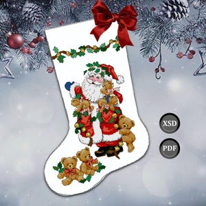 Peut inclure: Chaussette de Noël blanche avec un motif de point de croix du Père Noël tenant des ours en peluche. La chaussette est ornée d'un nœud rouge et d'une guirlande de houx. Le texte "XSD" et "PDF" est également inclus.