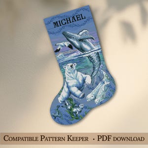 May include: A blue Christmas stocking featuring a cross-stitch pattern of an Arctic scene with a polar bear, a breaching whale, a beluga whale, and a seal. The name MICHAEL is printed in black capital letters at the top of the stocking design.