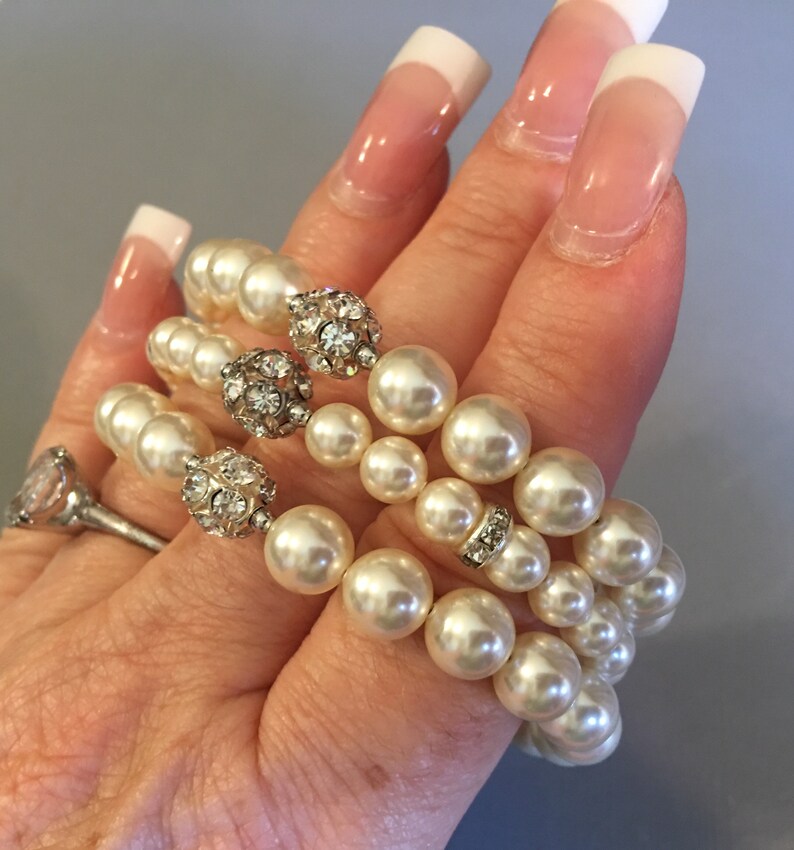 pearl bracelet with rhinestone accents. The bracelet has 3 strands pearls stacked on top of each other and are a cream color.