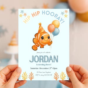 May include: A light blue birthday invitation featuring a cartoon clownfish holding balloons. The invitation reads "HIP HIP HOORAY!" and "JORDAN is turning three!" with event details. Decorative elements include stars and coral.