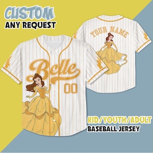 Op de afbeelding: Wit honkbalshirt met gouden krijtstrepen, met een cartoonafbeelding van Belle in een gele jurk. Het shirt heeft de naam "Belle" en het nummer "00" op de voorkant. De achterkant van het shirt heeft de tekst "YOUR NAME" en een andere Belle-afbeelding.