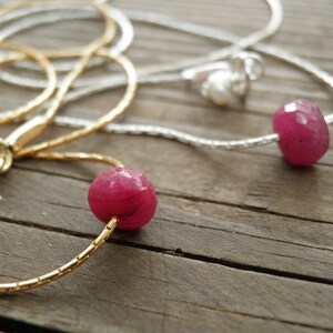 Puede incluir: Dos collares con cuentas de piedras preciosas rosas. Un collar es de oro y el otro es de plata.