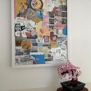 Peut inclure: Un tableau d'affichage en liège encadré de blanc avec un collage d'autocollants, de photos et de dessins colorés. Le collage comprend des images de personnages d'anime, de monuments japonais et de souvenirs de voyage. Le tableau d'affichage est accroché à un mur blanc.