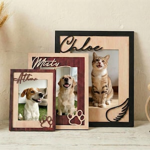 May include: A collection of personalized pet photo frames. Each frame features a pet's photo and name, with paw print accents. The frames are made of wood and have a rustic, natural look. The names "Athena", "Misty", and "Chloe" are displayed.