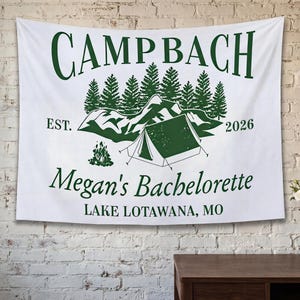 May include: A white ceramic mug with a black handle and the text "But First, Coffee" in a black, handwritten-style font. The mug is on a white surface.