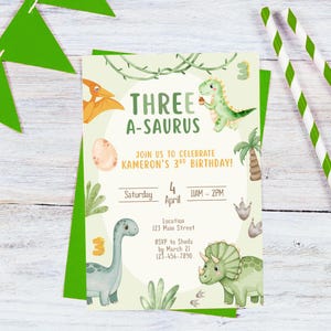 以下が含まれることがあります： 「THREE A-SAURUS」と「JOIN US TO CELEBRATE KAMERON'S 3RD BIRTHDAY!」の文字が入った、薄緑色の恐竜をテーマにした誕生日招待状。 招待状には、恐竜、ヤシの木、足跡のイラストが含まれています。 日付は4月4日、午前11時から午後2時です。