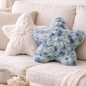 Puede incluir: Dos cojines decorativos con forma de estrella. Uno es blanco, el otro azul y verde. Ambos cojines est&aacute;n hechos de un material suave y texturizado y est&aacute;n colocados sobre un sof&aacute; beige. Los cojines a&ntilde;aden un toque de fantas&iacute;a a la decoraci&oacute;n.