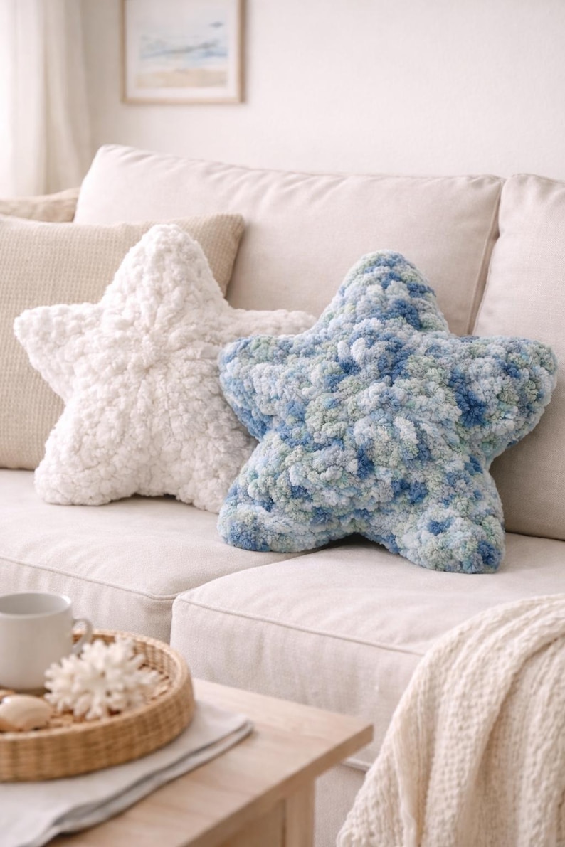 Puede incluir: Dos cojines decorativos con forma de estrella. Uno es blanco, el otro azul y verde. Ambos cojines est&aacute;n hechos de un material suave y texturizado y est&aacute;n colocados sobre un sof&aacute; beige. Los cojines a&ntilde;aden un toque de fantas&iacute;a a la decoraci&oacute;n.