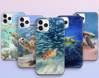 May include: A collection of five phone cases featuring vibrant underwater scenes. Each case showcases a different sea turtle design, with backgrounds of coral reefs, schools of fish, and sandy ocean floors. The cases are designed to fit a smartphone.