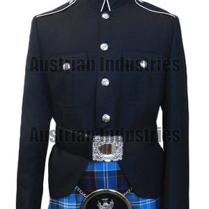 Pode incluir: Casaco militar azul marinho com botões prateados e debrum branco. O casaco tem dois bolsos frontais e um cinto a condizer com fivela prateada. Um kilt escocês xadrez azul e preto é visível por baixo.