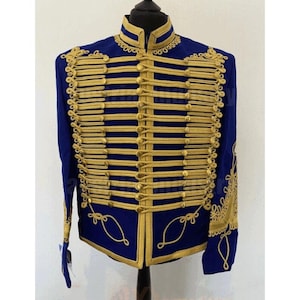 Può includere: Giacca blu navy in stile militare con finiture e dettagli dorati. La giacca presenta un colletto alto, più file di trecce dorate e ricami dorati decorativi sulle maniche. La giacca è esposta su un manichino nero.