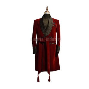 May include: A burgundy velvet robe with a black quilted shawl collar and cuffs. The robe has a matching belt and tassel details. The text "austria industry" is visible on the garment.